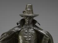 The figure looks directly at the viewer, with large hat and cape. The hat casts a shadow over part of the figure's face as detailed later. 