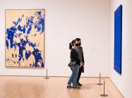 Visitors inside of SFMOMA, looking at paintings 