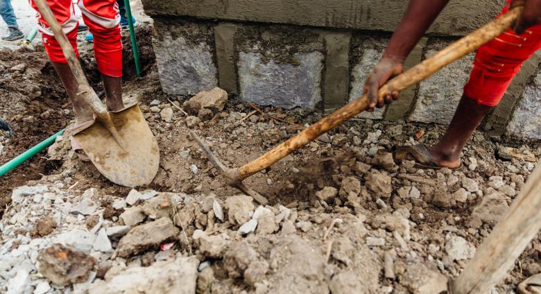 people digging in rubble