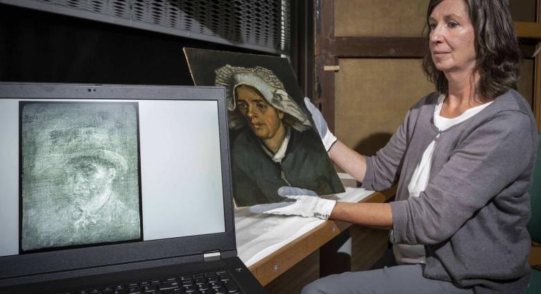 Senior Conservator Lesley Stevenson views Head of a Peasant Woman alongside an x-ray image of the hidden Van Gogh self-portrait. Photograph by Neil Hanna 