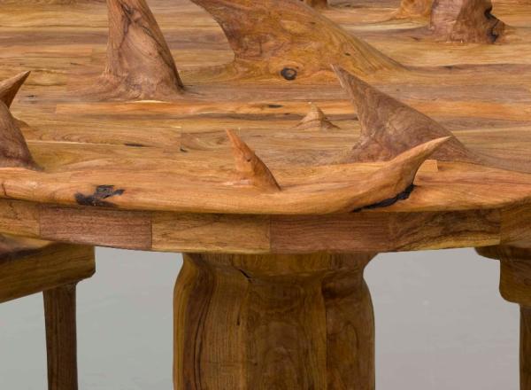 a circular wooden table and chairs, all covered in large thorny protrusions